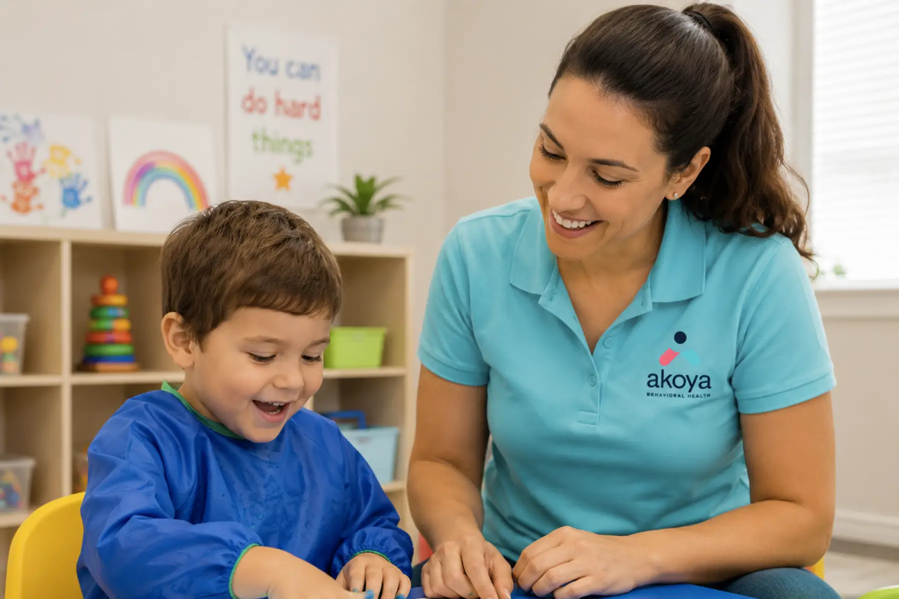 Child painting with therapist